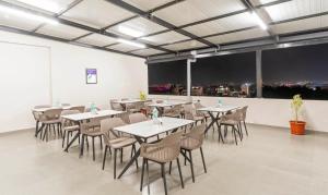 een eetkamer met tafels en stoelen en uitzicht bij Treebo Global Orchid in Mysore