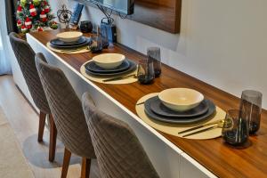 a table with chairs and bowls and plates on it at Zoned MASLAČAK lux - SPA & Wellness Kopaonik in Kopaonik
