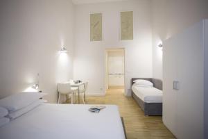 a hotel room with two beds and a table at Ripetta 25 Prestige Rooms in Rome