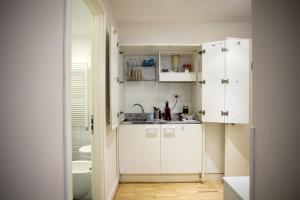 a small kitchen with white cabinets and a sink at Ripetta 25 Prestige Rooms in Rome