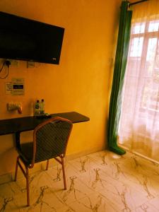 a room with a desk and a chair and a window at Wonderful Guesthouse in Kimana