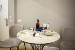 a table with a bowl of food on it with two chairs at Ripetta 25 Prestige Rooms in Rome