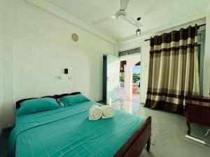 a bedroom with a bed with two towels on it at Nice Days Resort Unawatuna in Unawatuna
