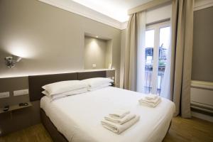a bedroom with a white bed with towels on it at Ripetta 25 Prestige Rooms in Rome
