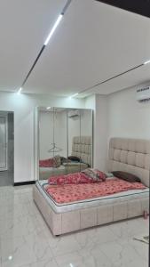 ein großes Bett in einem Zimmer mit Spiegel in der Unterkunft ميرا للشقق الفندقية in al-Ain