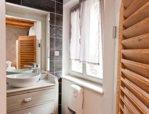een badkamer met 2 wastafels en een raam bij Gite des Frères Mertian in Ribeauvillé
