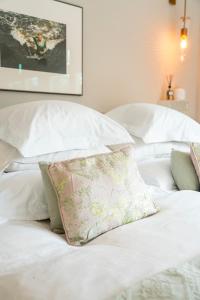 a bed with white sheets and a pillow on it at The Gentle Arch Schiphol Amsterdam in Aalsmeer