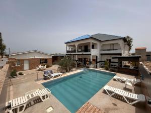 uma piscina com cadeiras e uma casa em Mdf Saloum em Poundiougne