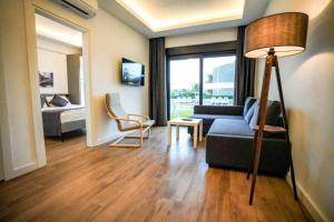 una sala de estar con un sofá y una cama en Sweet Home Kemer Apartments, en Kemer