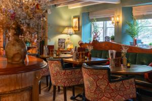 a restaurant with tables and chairs in a room at The Welldiggers Arms in Petworth