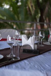 a table with wine glasses and a reserved plate on it at Neel Farms and Resort in Saoner