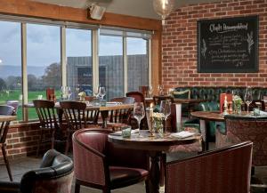 a restaurant with tables and chairs and a brick wall at The Welldiggers Arms in Petworth