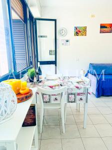 a kitchen with a white table with chairs and a tableablish at Giglio Rosa 4 n9 in Campese +4 photos