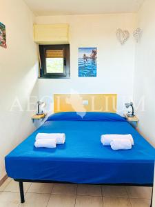 ein Schlafzimmer mit einem blauen Bett mit zwei Handtüchern darauf in der Unterkunft Giglio Rosa 4 n9 in Campese