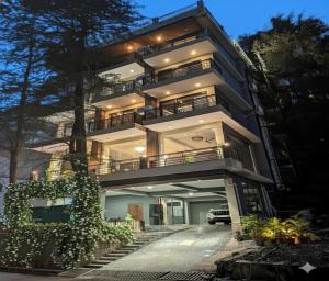 Un gran edificio con escaleras que conducen hasta él. en LA Riqueza Koala Inn Mcleod Ganj - Top Selling - Award Winning Hotel - Mountain View Rooms - Near to Mall Road, en McLeod Ganj