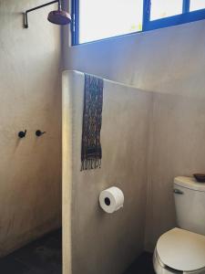 ein Badezimmer mit Toilette und einem Handtuch an der Wand in der Unterkunft Quiet Oceanside Casita Private Kitchen & Bath in Troncones