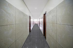 Hotel O Jodi Sri Muneshwara Swamy Temple في Jālahalli: مدخل مع ممر طويل مع أبواب خشبية