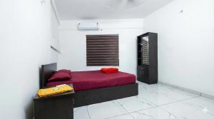 a bedroom with a bed with a red blanket at SAIS LINE Residency in Kozhikode