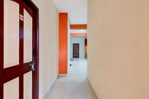 ein leerer Korridor mit einer Tür und ein Flur mit einer Orange in der Unterkunft Hotel O Rela Hospital Chromepet Formerly Sri Ram Ganesh Residency in Chennai