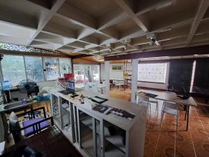 een kamer met een tafel, stoelen en ramen bij Casa Scarlet in Bangkok