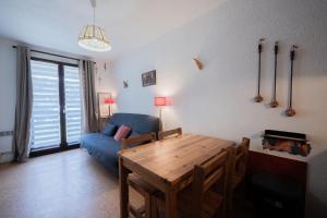 a living room with a blue couch and a table at Studio Cabine Ax Les 3 Domaines in Ax-Bonascre