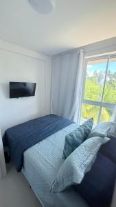 una camera da letto con un letto grande con una finestra di Mila rooftop apto 308 a Tamandaré