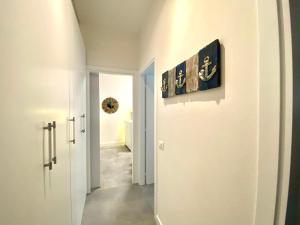 Civico 148- Lido di Jesolo - Per Famiglie في ليدو دي يسولو: ممر بجدران بيضاء وباب فيه لوحة
