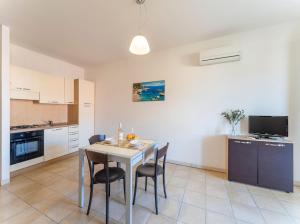 a kitchen and dining room with a table and chairs at Premium apartment in Villasimius in Villasimius