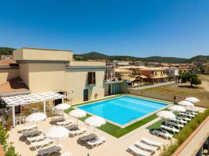 a villa with a swimming pool and lounge chairs at Premium apartment in Villasimius in Villasimius