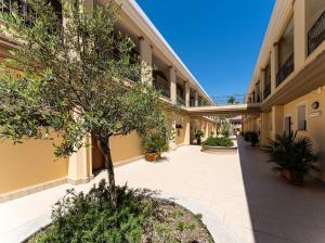 an empty hallway of a building with a tree in a courtyard at Premium apartment in Villasimius in Villasimius