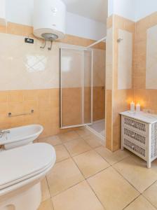 a bathroom with a shower and a toilet and a sink at Premium apartment in Villasimius in Villasimius +19 photos