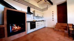 a kitchen with a fireplace in the middle of a room at La Casetta del Pàstine, Il Borgo Diffuso di San Michele in San Michele in Teverina +29 photos