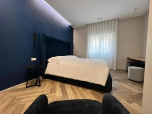 a bedroom with a large bed with a blue wall at Telese Charme B&B in Telese