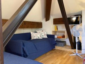 Una sala de estar con un sofá azul y un televisor en Sassiglioni Vacanze, en Sassiglioni