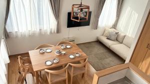 a small living room with a wooden table and chairs at Sa one ko松本 in Matsumoto