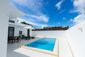 una piscina nel cortile di una villa di 2025年12月オープンのリベルテ瀬底サウナプールで整う1棟貸 a Sesoko