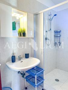 a white bathroom with a sink and a shower at Castello 4 in Isola del Giglio
