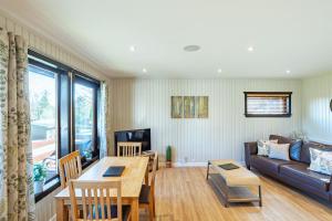 a living room with a table and a couch at Birch Lodge 15 in Newton Stewart