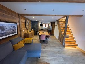 ein Wohnzimmer mit Sofa und Tisch in der Unterkunft Meribel Chalet de Séverine in Les Allues