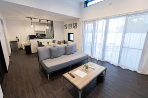 un soggiorno con un divano e un tavolo di 2025年12月オープンのリベルテ瀬底サウナプールで整う1棟貸 a Sesoko