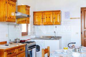 a kitchen with wooden cabinets and a stove top oven at Castello 4 in Isola del Giglio +13 photos