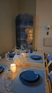 a table with blue plates and wine glasses on it at Aries' Collection Luxury Suites in Braşov