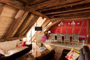 a living room with wooden ceilings and a red wall at Gite des Frères Mertian in Ribeauvillé