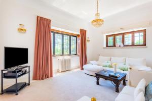 ein Wohnzimmer mit Sofa und Fernseher in der Unterkunft Estoril Royal Atlantic Villa with Ocean View in Estoril