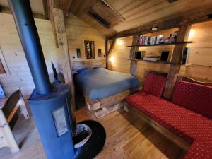a room with a stove and a couch and a bed at Chalet Chamois & Spa in Lullin