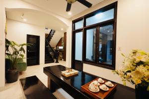 フエにあるNana Villa Hueのテーブルと大きな窓のあるリビングルーム