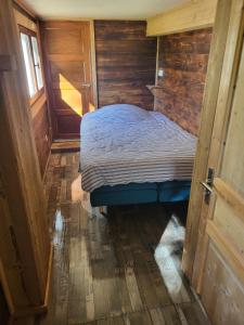 een kleine slaapkamer met een bed in een houten hut bij Chalet Chamois & Spa in Lullin
