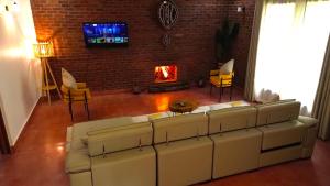 a living room with a couch and a fireplace at Kerama Silent Lodge in Arusha