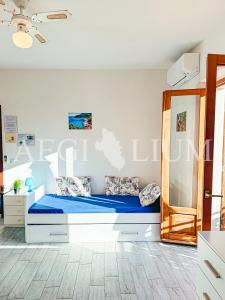 ein weißes Schlafzimmer mit einem Bett mit blauer Bettwäsche in der Unterkunft Giuliana 4 in Campese