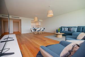 a living room with a blue couch and a table at Bayline X in Armação de Pêra +28 photos